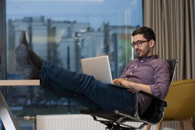 Genç işadamı ofiste onun laptop üzerinde çalışıyor