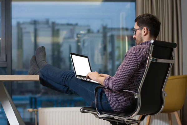 Молодой бизнесмен работает над своим ноутбуком в офисе Стоковое Фото