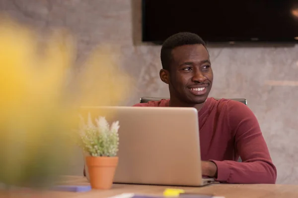 Молодой афро-американский бизнесмен работает над своим ноутбуком в Лицензионные Стоковые Фото