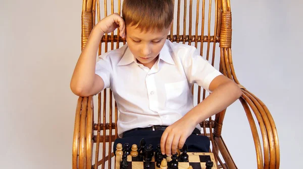 Poważny chłopak gra szachy — Zdjęcie stockowe