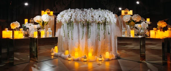 Mesa de casamento dos recém-casados decorados com velas em um fundo preto — Fotografia de Stock