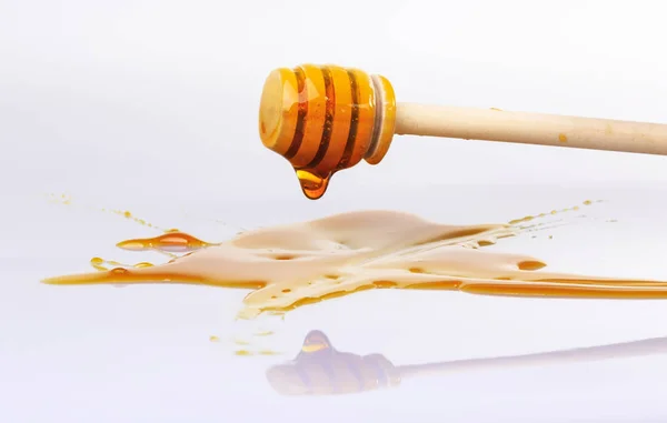 蜂蜜の蜂蜜のための木製ディッパーから滴り落ちる ロイヤリティフリーのストック画像