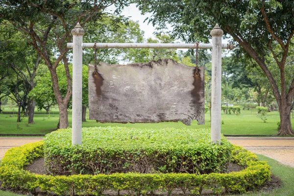 Placa de madeira pendurada na barra branca dentro do parque público — Fotografia de Stock