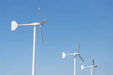 Mavi gökyüzü üzerinde üç rüzgar türbini