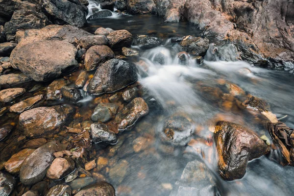Вода тече на коричневих каменях — стокове фото