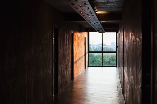 stock image Low key scene of big bright window at the end of walkway