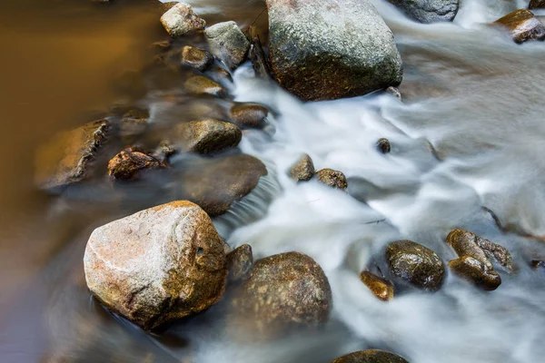 Kahverengi taş su yolu ile akan su — Stok fotoğraf