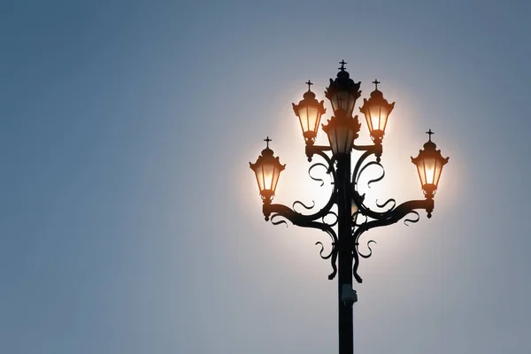 Lâmpadas brilhantes no céu azul com sol — Fotografia de Stock