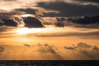 Altın bulutlu gün batımı gökyüzü gölge koyu deniz ile