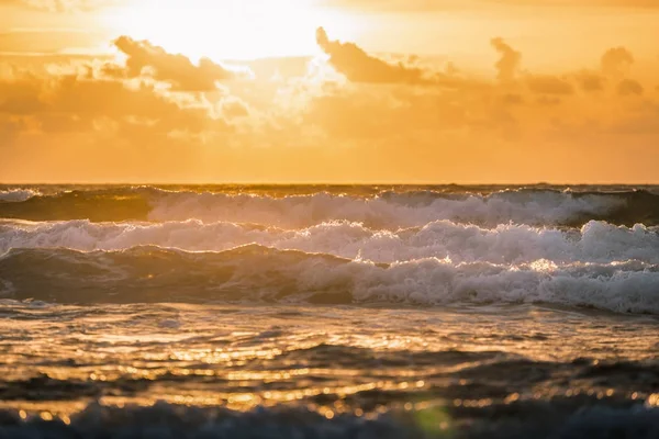 Grandes olas de mar oscuro con luz solar del cielo nublado dorado del atardecer —  Fotos de Stock