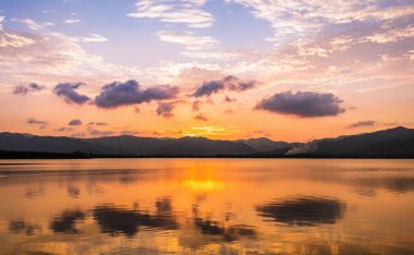 Açık göl üzerinde bulut ve alacakaranlık gökyüzü yansıması