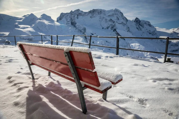 Banco cubierto de nieve en la terraza para ver las montañas nevadas —  Fotos de Stock