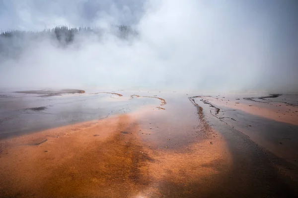 Smoke covered orange pond of geyser basin. — Stock Photo, Image