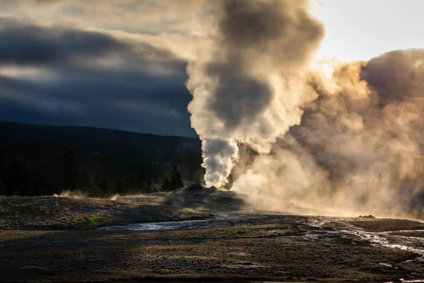 Old Faithful geyser exploded smoke with warm sunlight in early m