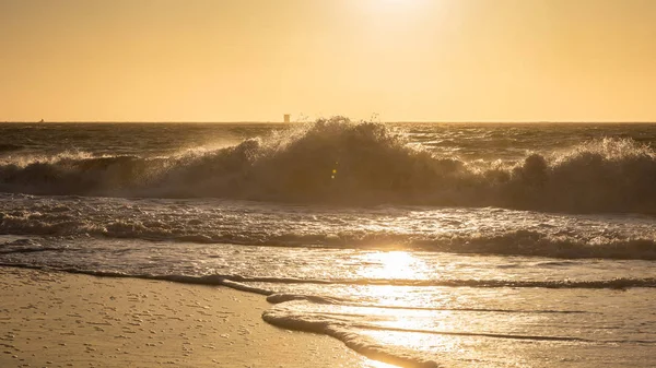 Большая волна от сильного ветра касается большой скалы Бейкер Бич на солнце — стоковое фото