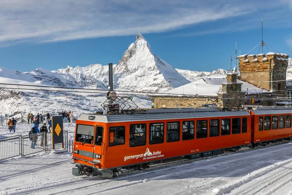 Gornergrat, Zermatt, İsviçre - 12 Kasım 2019: Karlı tren istasyonunda kışın Matterhorn zirvesinin arka planına sahip kırmızı teleferik treni.