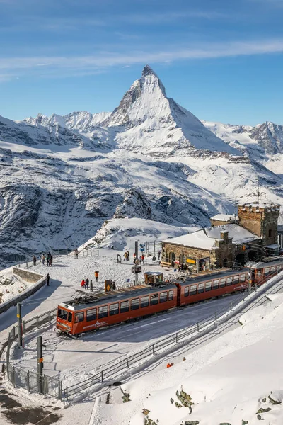 Gornergrat, Zermatt, İsviçre - 12 Kasım 2019: Karlı tren istasyonunda turistler ve Matterhorn zirvesinde kışın.