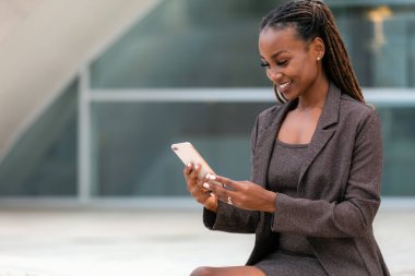 Ofisteki güzel Afrikalı iş kadını akıllı telefon teknolojisi kullanıyor, 5g, 4g, Lte, geniş bant internet.