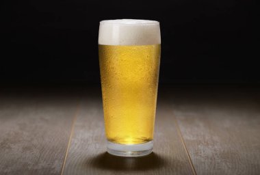 Bir bardak Pale Ale, bira, bira, bira ahşap yüzey ve siyah arka plan üzerine bira.