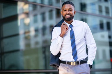 Handsome stylish trendy suit, african american businessman portrait downtown in city building, smiling with success and success