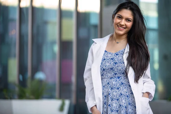 Mixed ethnicity college grad student in the medical field, possibly intern for dentistry, psychiatry, medicine, in lab coat