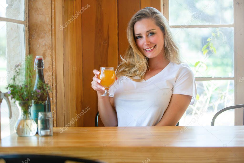 Lifestyle portrait of a person drinking a pint of wheat beer, Hefeweizen, IPA, hazy NEIPA, at a craft brewery 