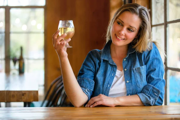 一个女人从水龙头里喝着新鲜的工艺苹果酒 举杯在酒吧为她的朋友们欢呼 — 图库照片