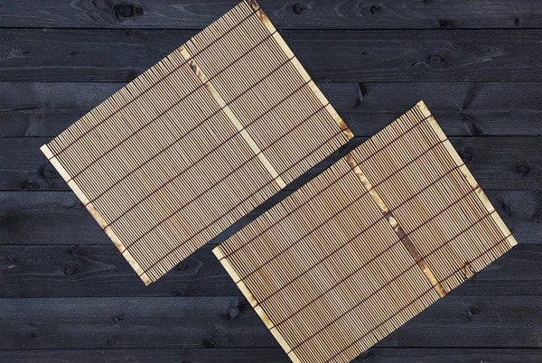 Бамбуковый коврик на деревянном столе, вид сверху — стоковое фото