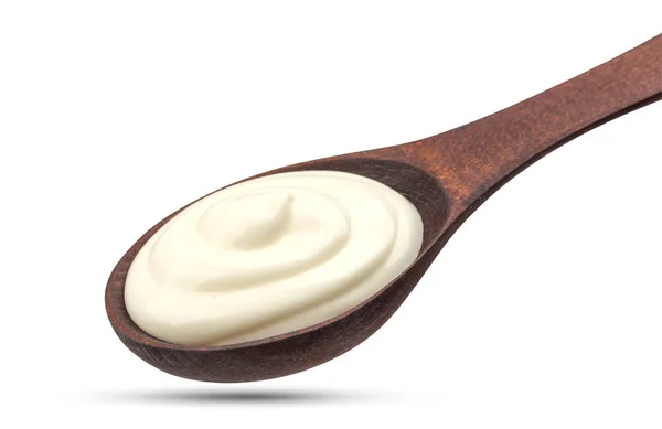 Sour cream in wooden spoon isolated on white background — Stock Photo, Image