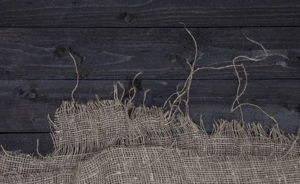 Тёмный деревянный стол с мешковиной, вид сверху — стоковое фото
