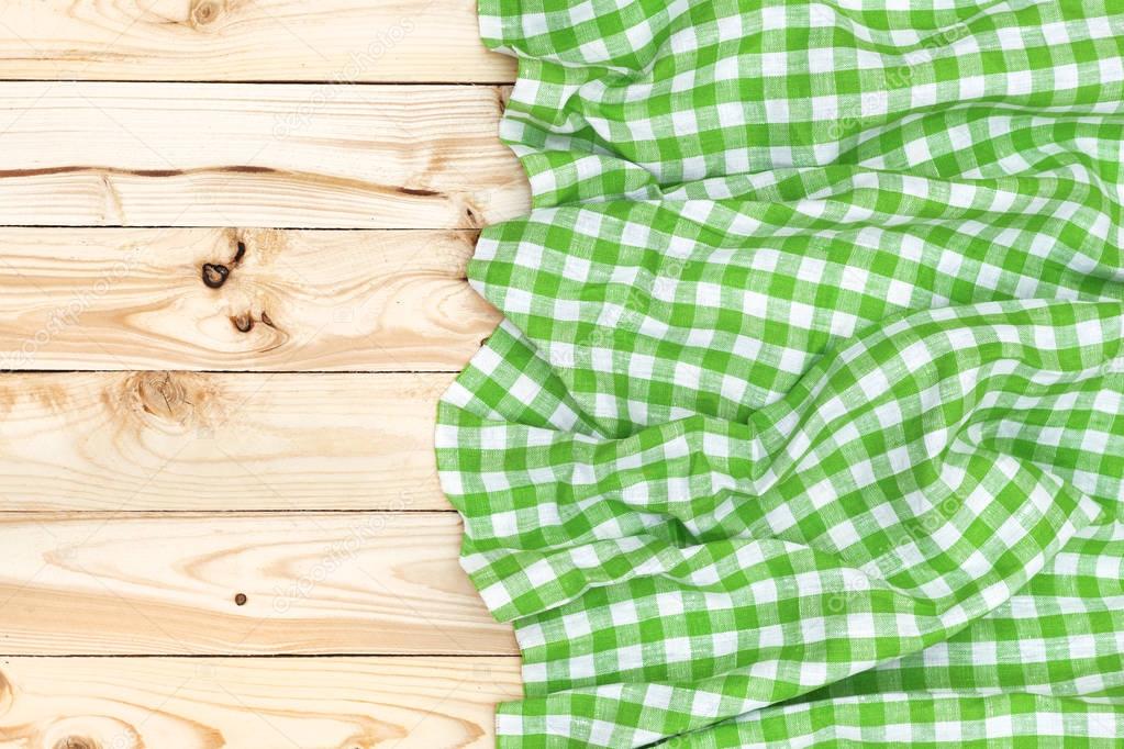 Green napkin on wooden table, top view