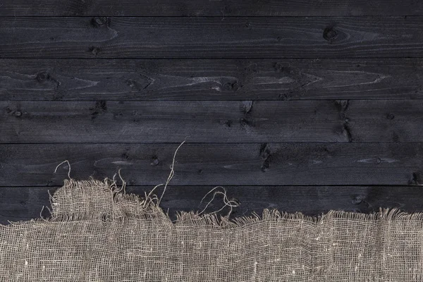 Mesa de madera negra con mantel de arpillera, vista superior, espacio para copiar —  Fotos de Stock