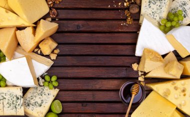 Boş alanı olan ahşap masa üzerinde çeşitli peynirler.