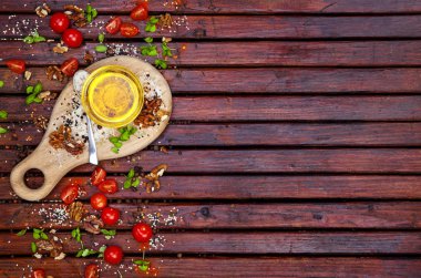 Gıda arka plan kopya alanı ile. Baharatlar, cherry domates, fesleğen ve koyu ahşap masa, bitkisel yağ görünümü top