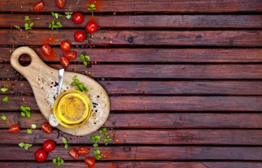 Gıda arka plan kopya alanı ile. Baharatlar, cherry domates, fesleğen ve koyu ahşap masa, bitkisel yağ görünümü top