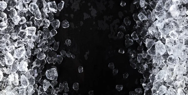 Pieces of crushed ice cubes on black background. Copy space, top view — Stock Photo, Image