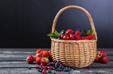 Taze orman meyveleri sepeti rustik ahşap zemin üzerinde. Kopya alanı