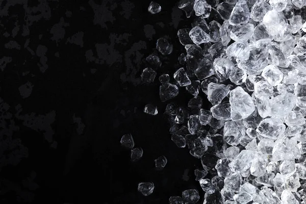 Шматочки подрібнених кубиків льоду на чорному тлі. Копіювати простір, вид зверху — стокове фото