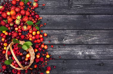 Taze orman meyveleri sepeti ahşap arka plan üzerinde. Kopya alanı