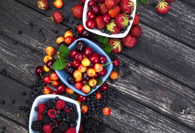 Ahşap arka plan üzerinde taze orman meyveleri. Üstten Görünüm