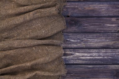 Çuval bezi üzerinde koyu ahşap arka plan, üstten görünüm