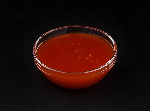 Гарячий соус чилі ізольований на чорному фоні — стокове фото