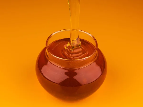 Gießen Honig isoliert auf gelbem Hintergrund — Stockfoto
