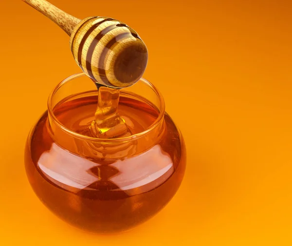 Honigstange und Schüssel mit Gießhonig isoliert auf gelbem Hintergrund — Stockfoto