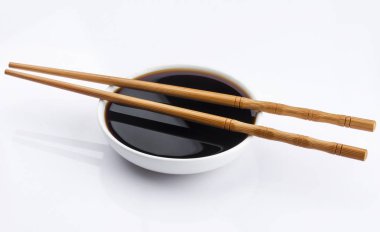 Soya sosu ve beyaz arka plan üzerinde izole chopsticks