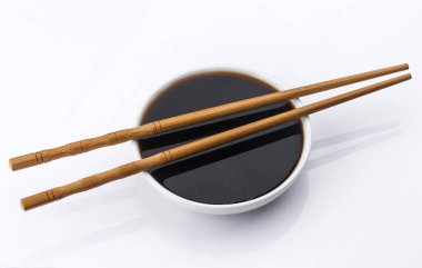 Soya sosu ve beyaz arka plan üzerinde izole chopsticks