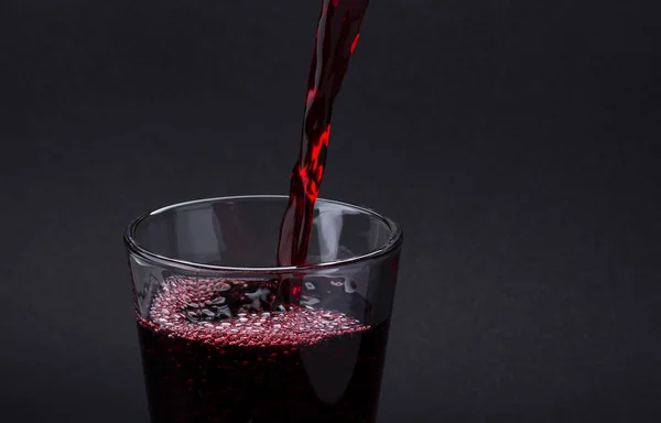 Verser une boisson au cola isolée sur fond noir — Photo
