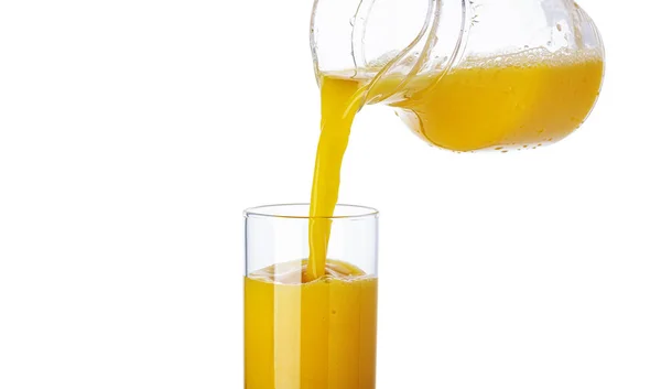 Jus d'orange versé du pichet dans un verre isolé sur fond blanc — Photo