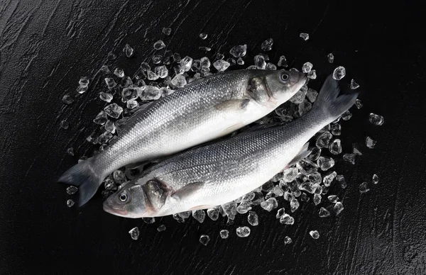 Θαλασσινά ψάρια στον πάγο σε μαύρο φόντο πέτρα, πάνω όψη — Φωτογραφία Αρχείου