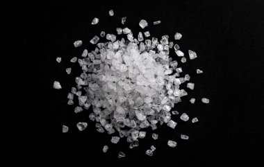 Pile of sea salt on black background clipart